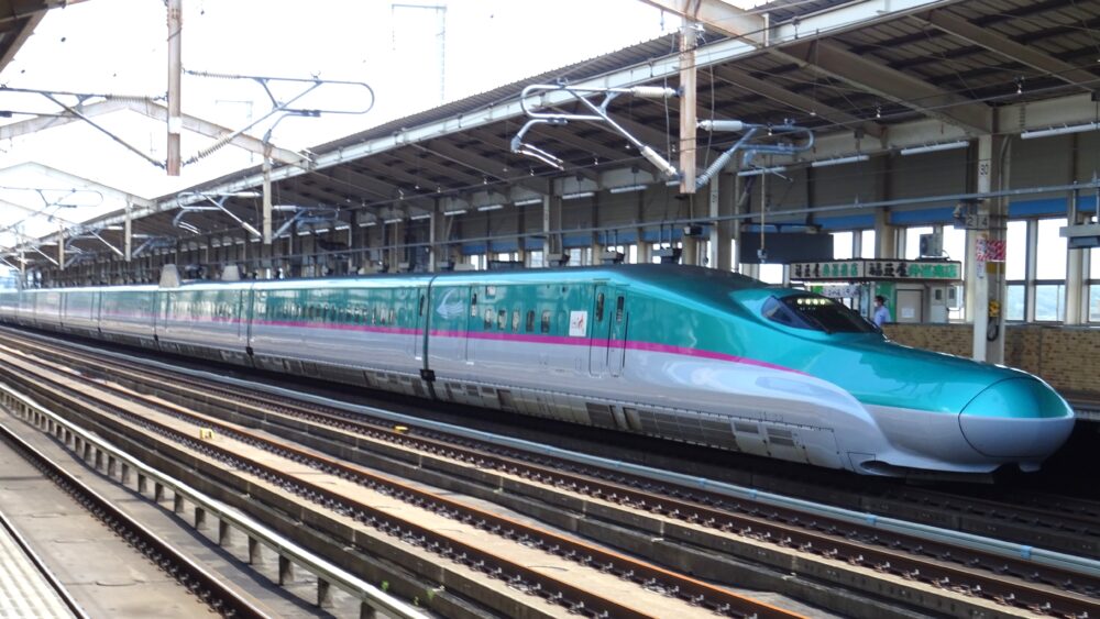 駅ホームに停車する緑色のE5系新幹線はやぶさ